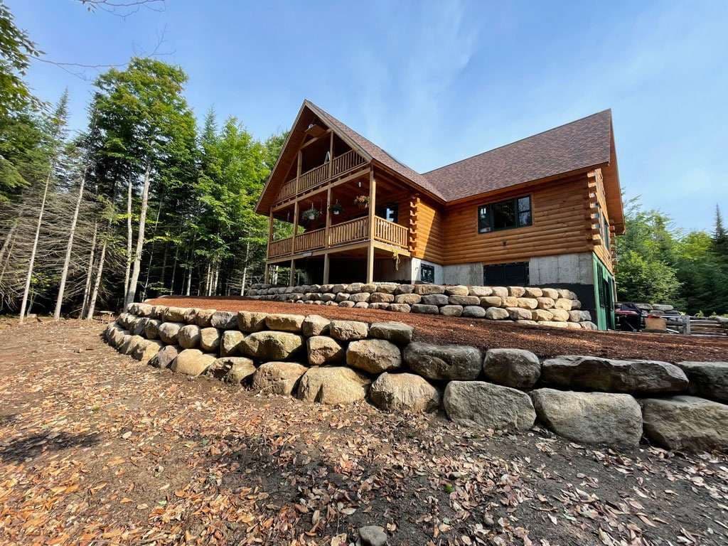 Log Home Enhanced with Sturdy Boulder Walls